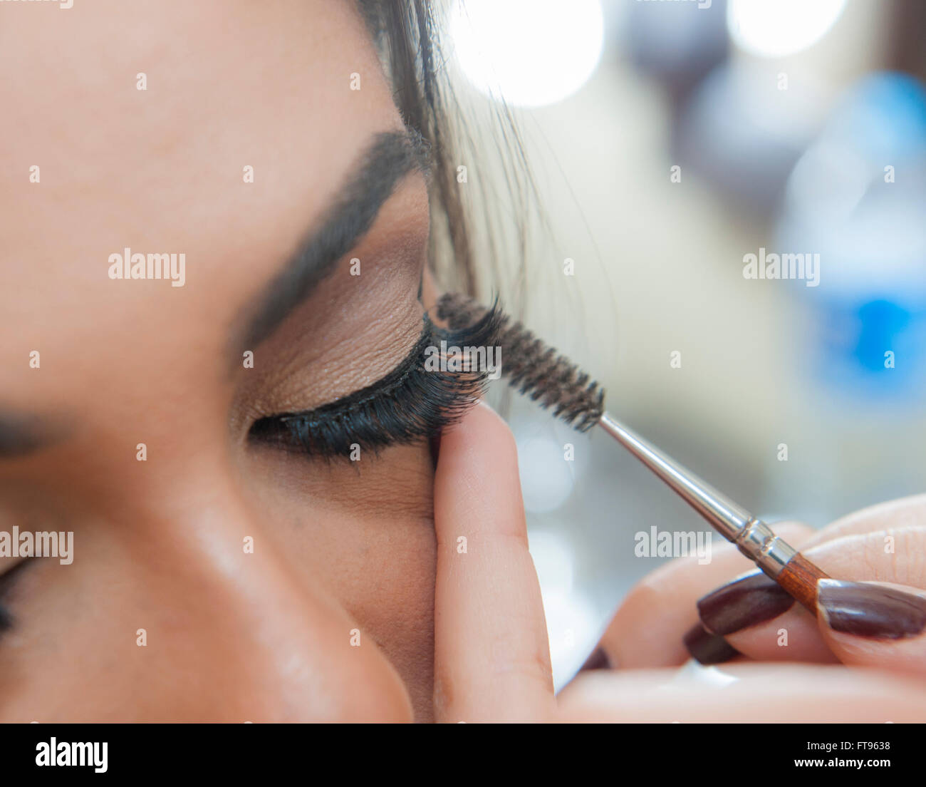 Closeup detail of womans eyelid and eyelash applying makeup mascara