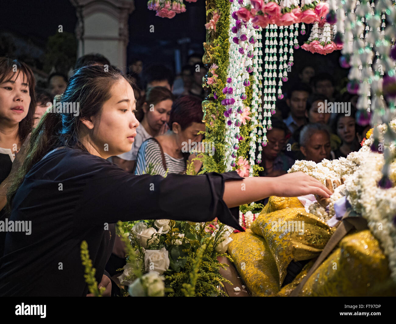 Bangkok, Bangkok, Thailand. 25th Mar, 2016. A woman reaches out to touch the hand of a statue of Jesus during Good Friday observances at Santa Cruz Church in Bangkok. Santa Cruz was one of the first Catholic churches established in Bangkok. It was built in the late 1700s by Portuguese soldiers allied with King Taksin the Great in his battles against the Burmese who invaded Thailand (then Siam). There are about 300,000 Catholics in Thailand, in 10 dioceses with 436 parishes. Good Friday marks the day Jesus Christ was crucified by the Romans and is one of the most important days in Catholicism Stock Photo