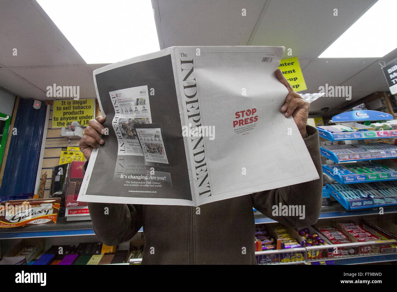 London, UK. 26th March 2016. A newsagent holds The final print edition of the British newspaper 'The Independent' which has been in circulation since 1986. The paper will now be available in a 'digital platform only' Credit:  amer ghazzal/Alamy Live News Stock Photo