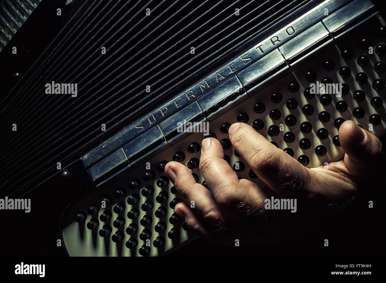 Conceptual composition about playing an accordion, details of a hand on an instrument while
