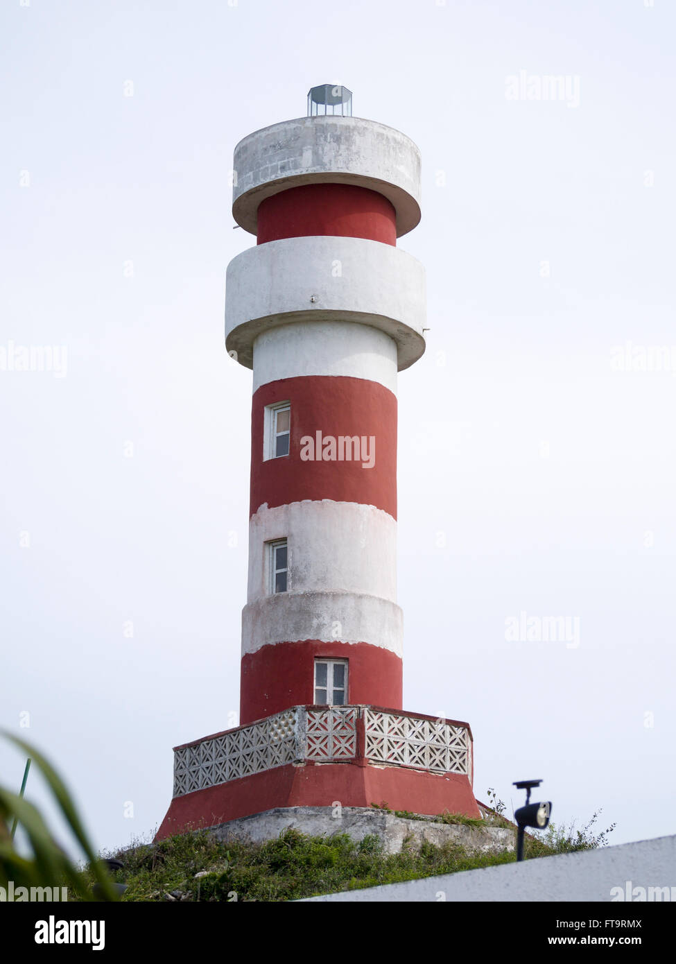 Red and White striped Lighthouse at El Cuyo. High above the village,a red and white striped lighthouse provides navigation aid Stock Photo