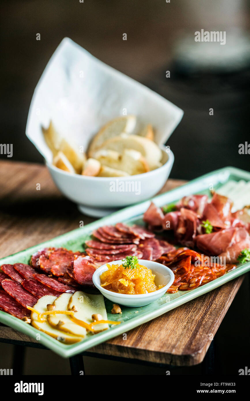 spanish traditional smoked meats serrano ham chorizo and cheese platter starter dish with quince jam and bread Stock Photo