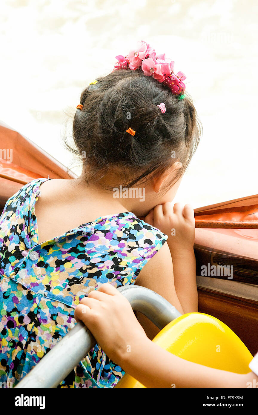 Pretty Asian Thai girl looking out with hair accessories on a river cruise on the Chao Phraya River in Bangkok,Thailand. Stock Photo