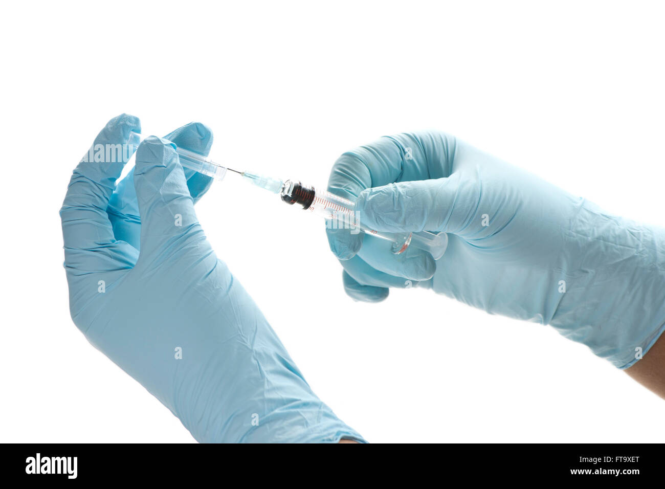 Nurse removes cap from syringe to prepare it for use. Stock Photo