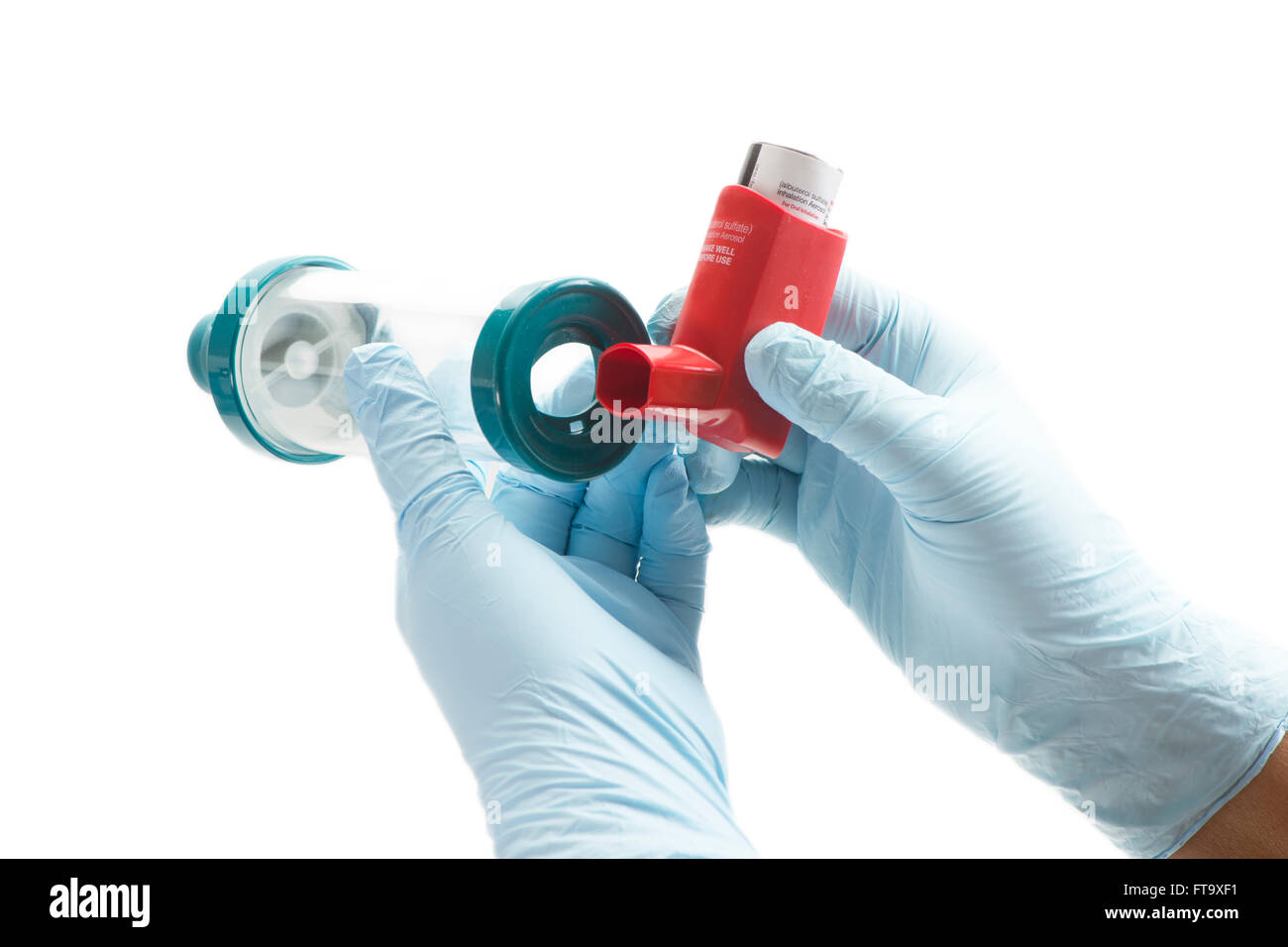 Nurse attaches spacer chamber to asthma inhaler.  Albuterol is a common medication name. Stock Photo