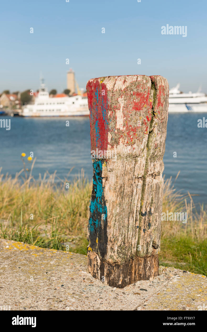Old weathered and beautifully colored mooring pole in the harbor of West-Terschelling in the North of the Netherlands Stock Photo