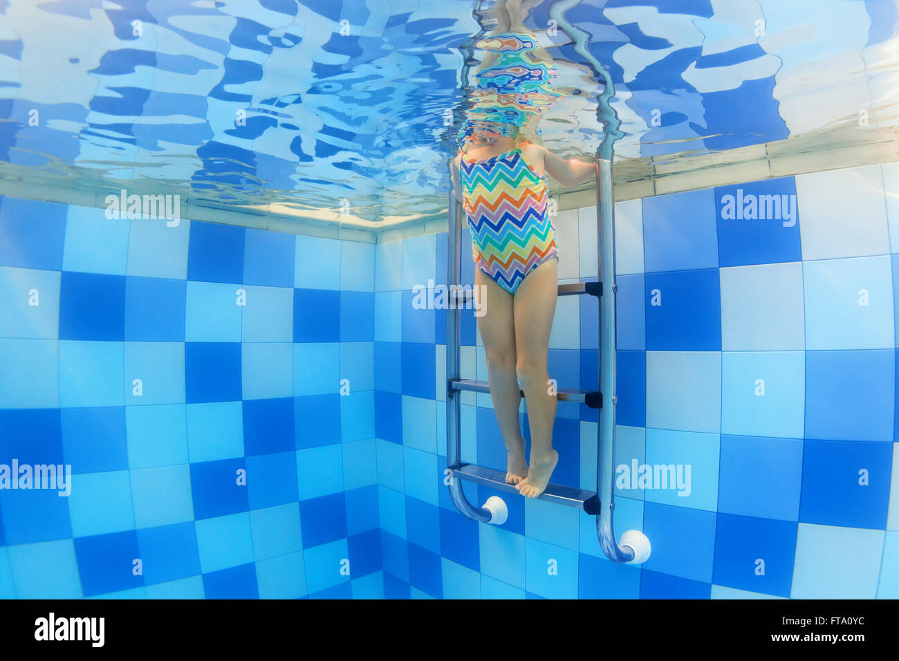 Background underwater photo of baby girl body standing on pool stairs