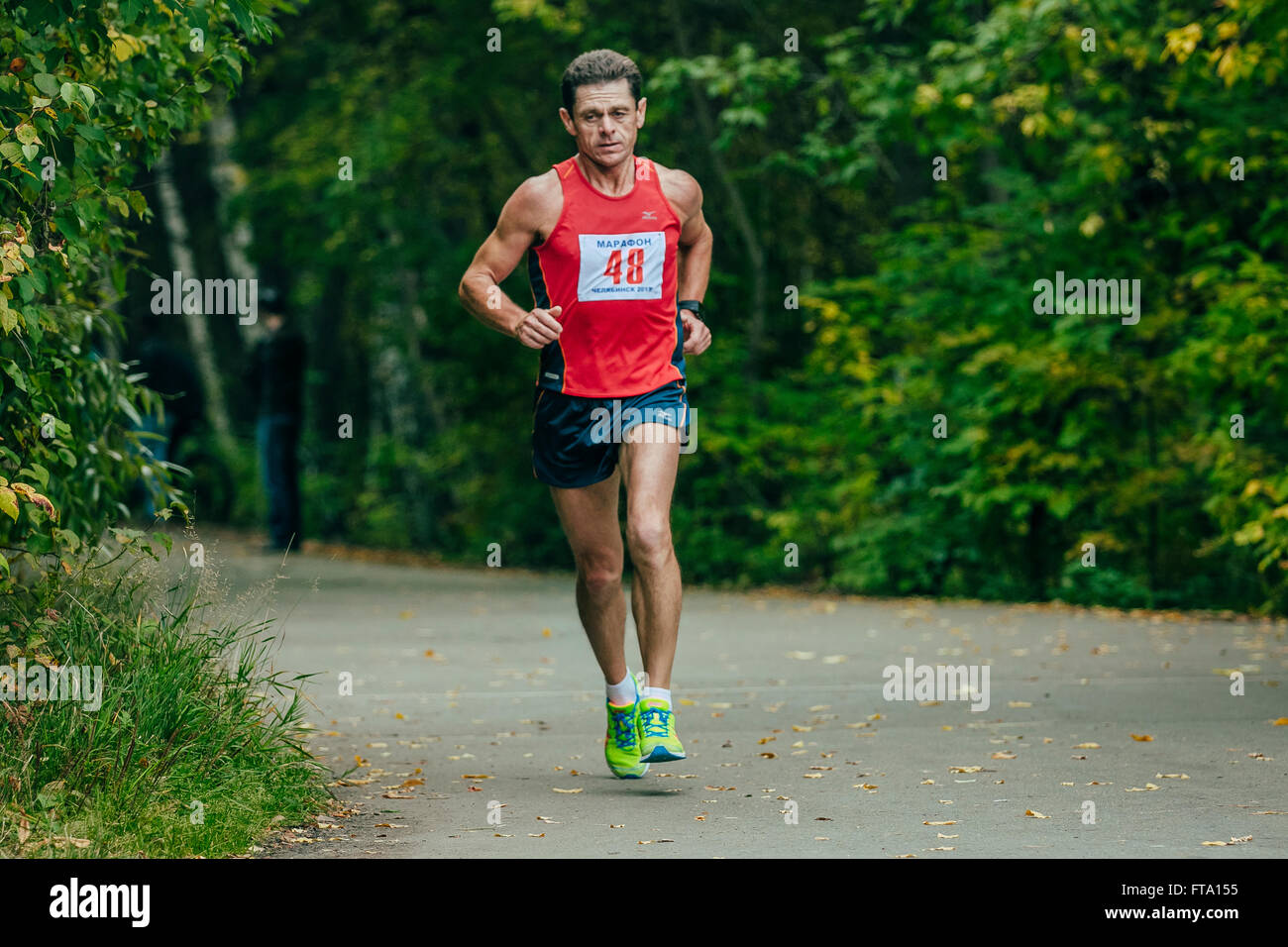 middle-aged athlete runs through the Park during Chelyabinsk marathon Stock Photo