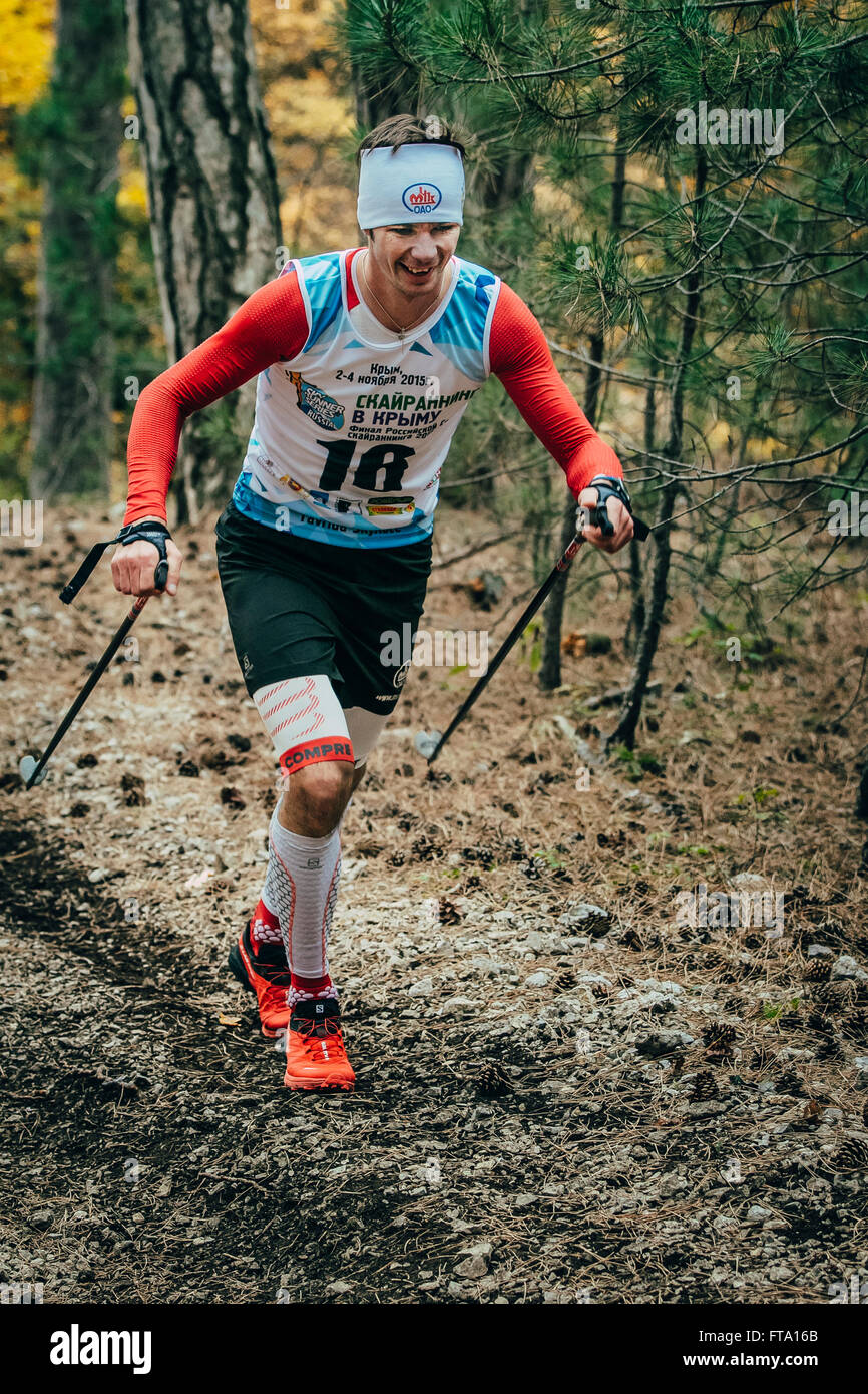 smiling athlete running with sticks to walk in compression socks during