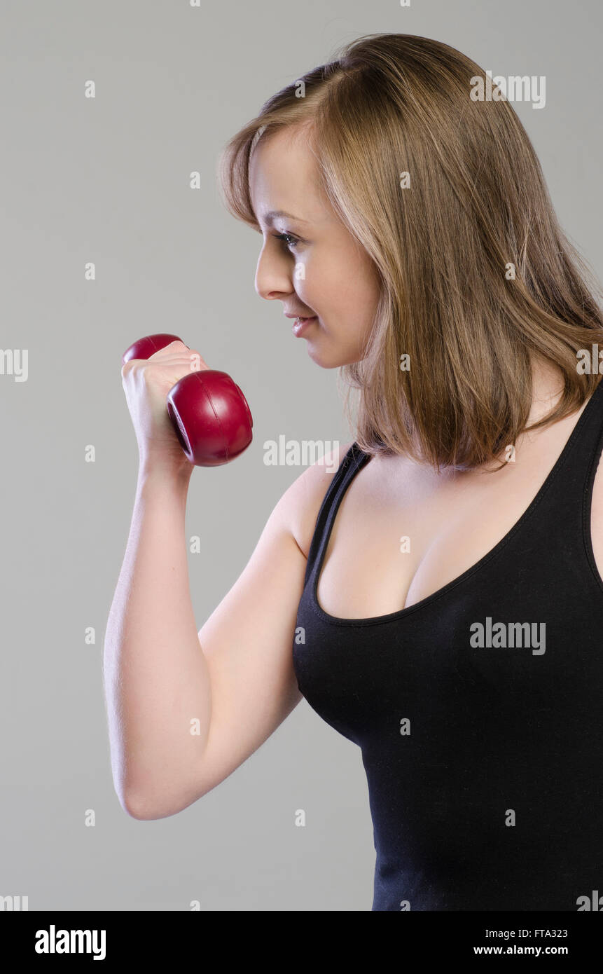 Beautiful young woman working out with dumbbells Stock Photo