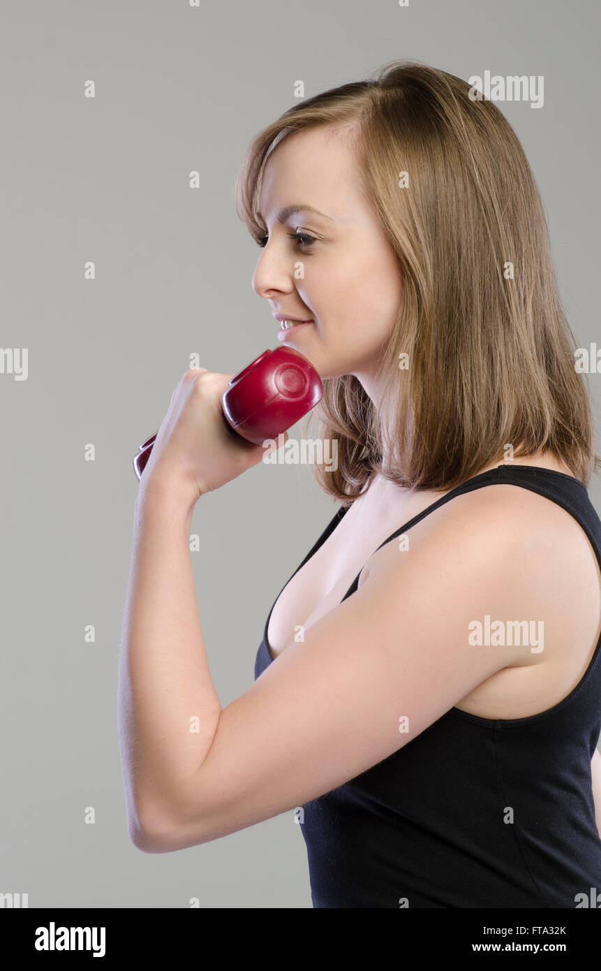Beautiful young woman working out with dumbbells Stock Photo