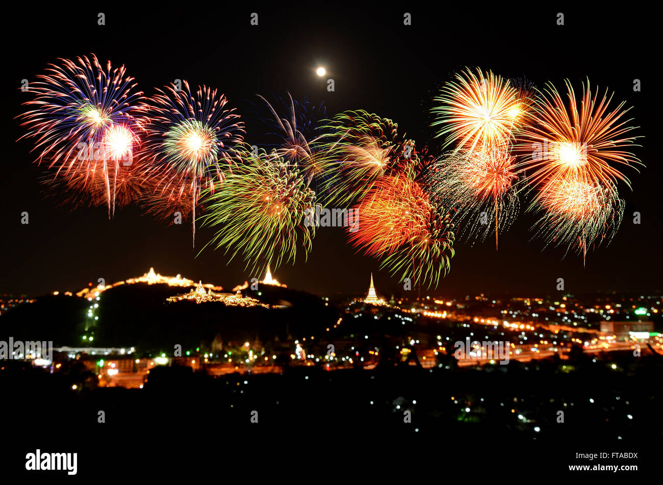 Colorful fireworks celebration and the city night light background. Stock Photo