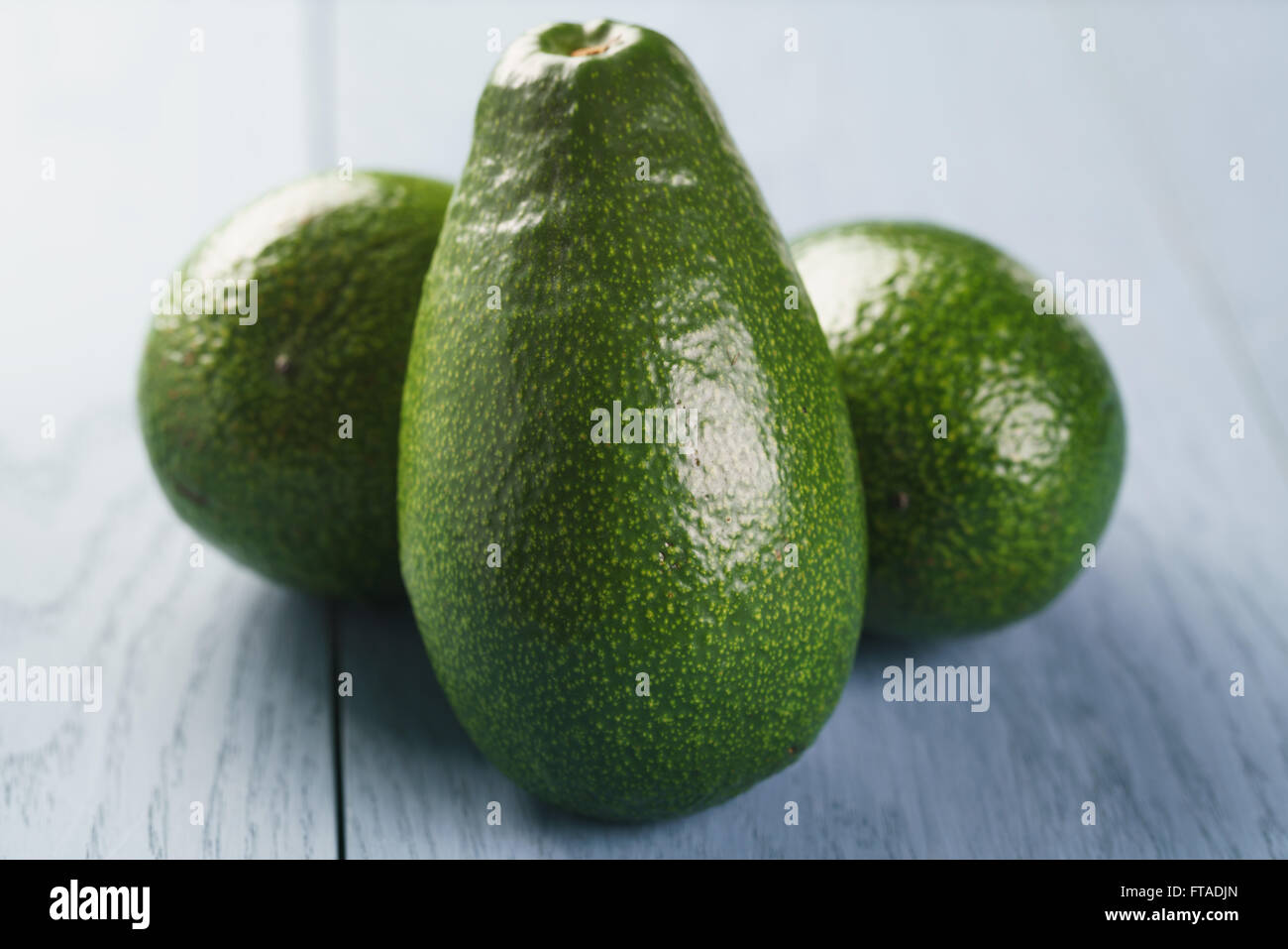 whole ripe green avocados on wood table Stock Photo