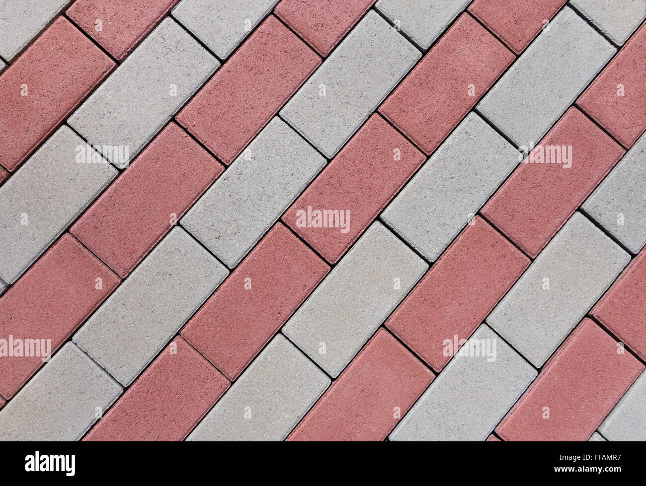 Diagonal pattern of rows of rectangular, red and gray cobblestones in close-up Stock Photo