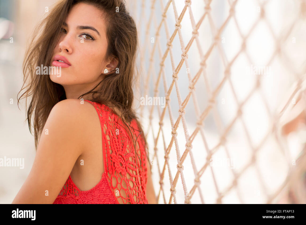 Young woman posing in a red dress outside Stock Photo - Alamy