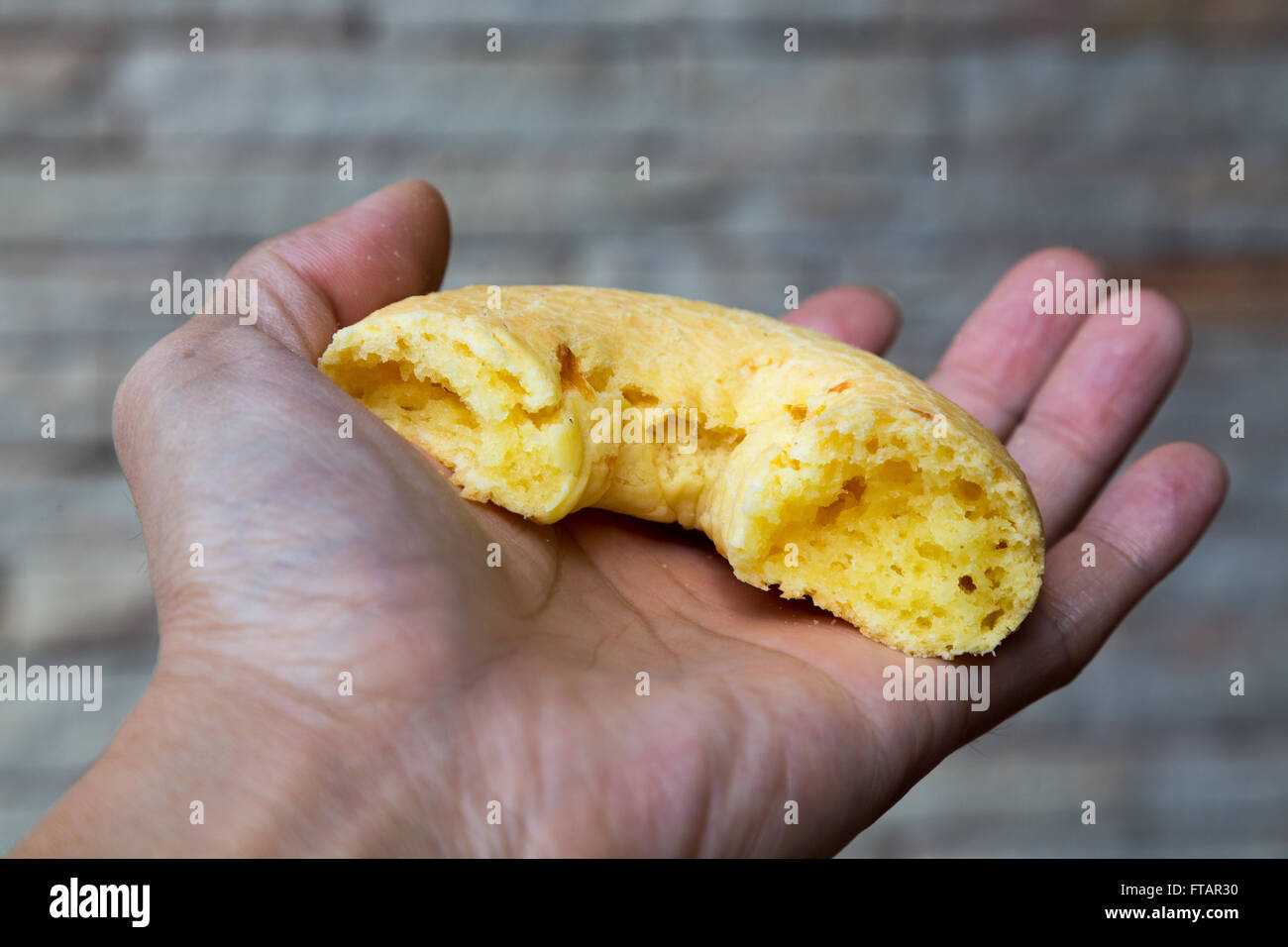 Hand holding typical Paraguayan chipa. Chipa is a type of baked, cheese-flavored rolls, a traditional snack and breakfast food Stock Photo
