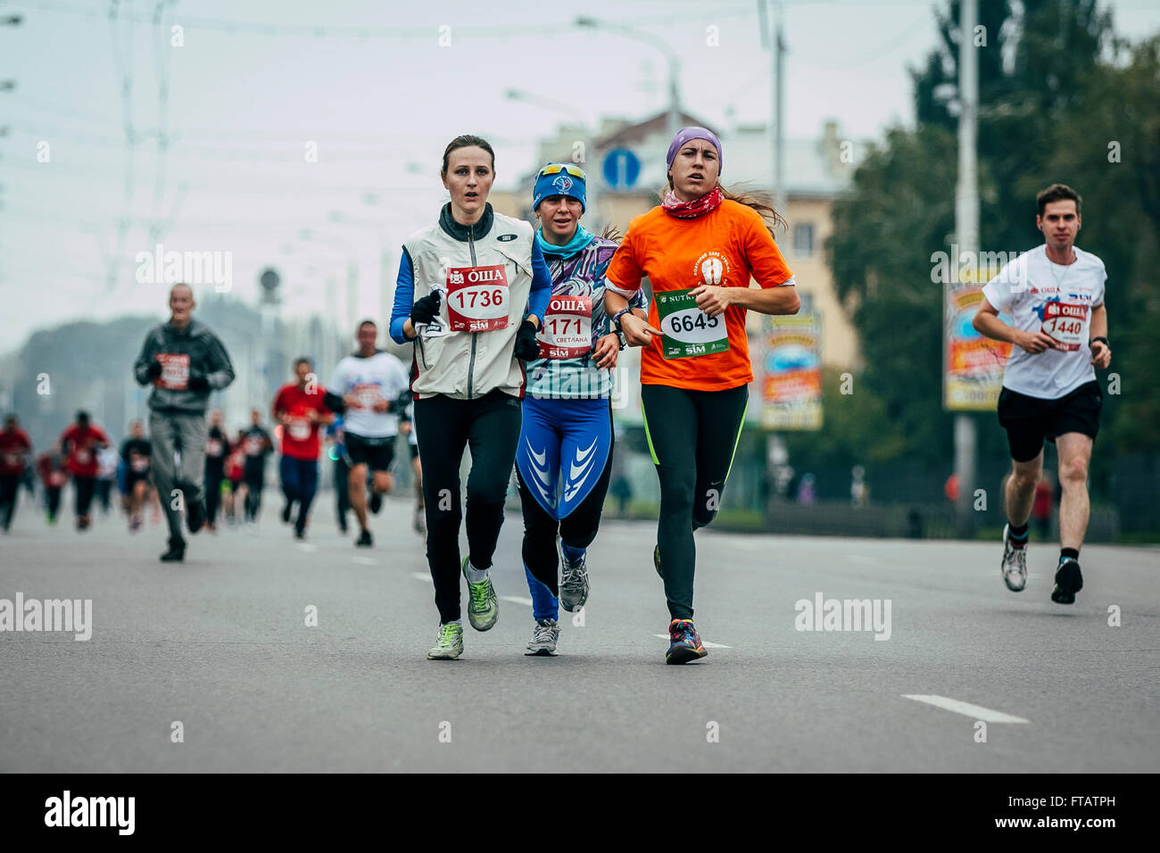 Omsk, Russia -  September 20, 2015: three girls runners run through streets of city during Siberian international marathon Stock Photo