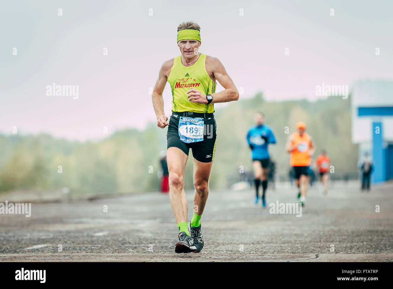 Omsk, Russia -  September 20, 2015: male athlete of middle age runs along river during Siberian international marathon Stock Photo