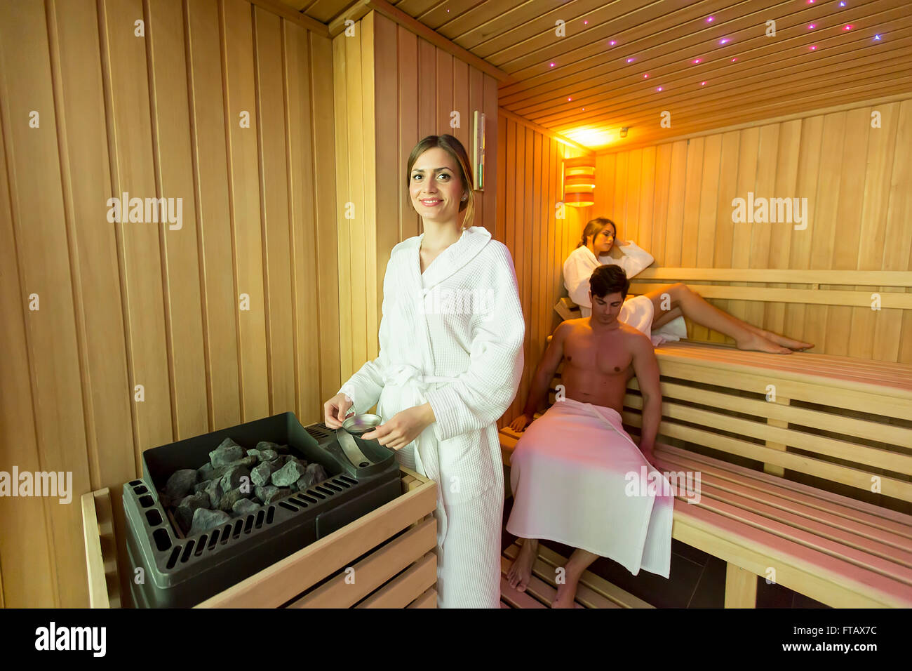 Woman pouring water on the rocks in the sauna Stock Photo Alamy