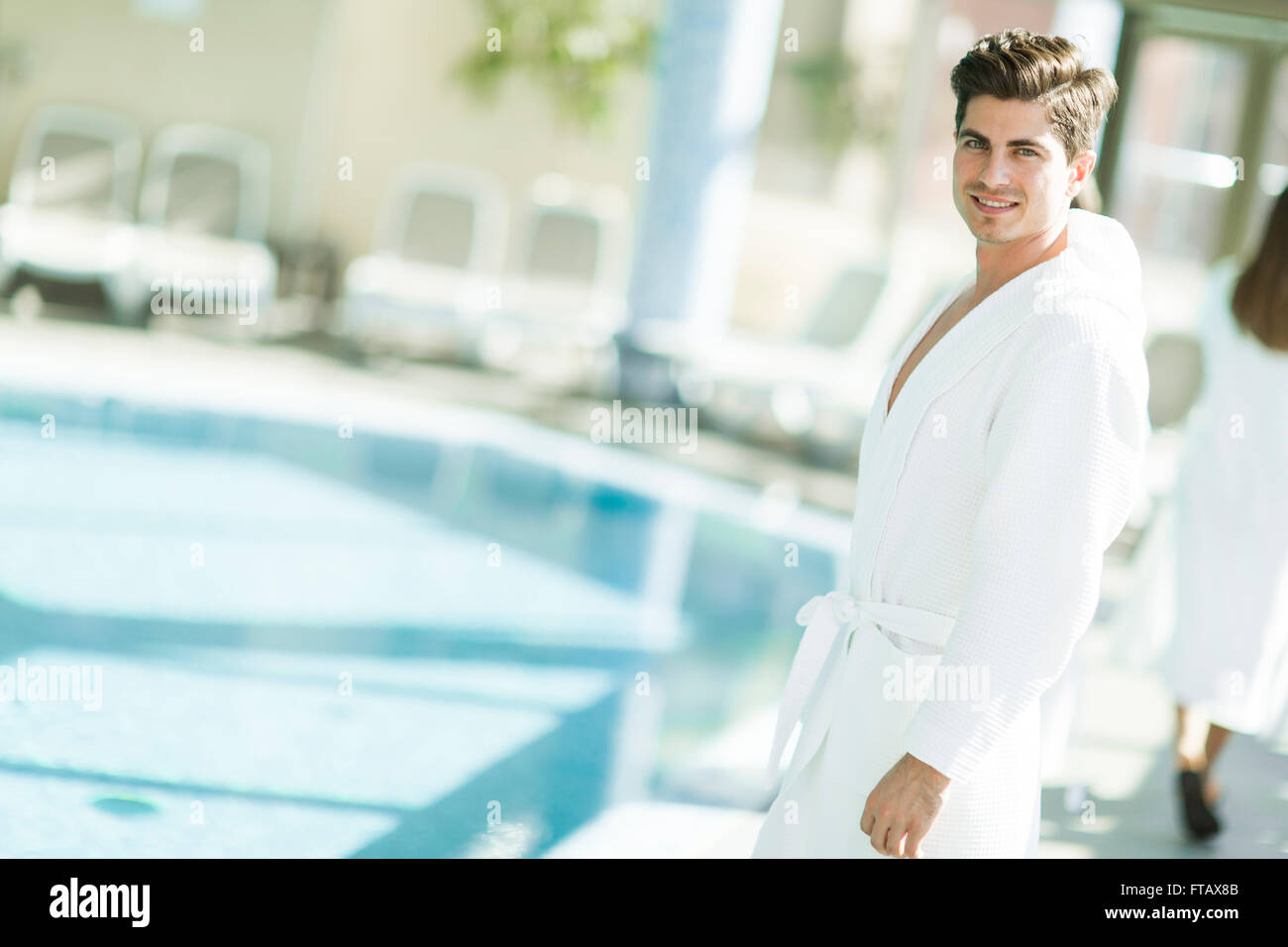Young man in a bathrobe standing in the spa Stock Photo - Alamy