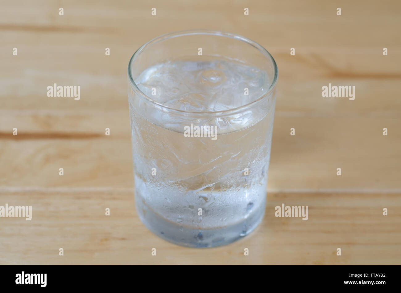 glass of water with ice on wooden table Stock Photo
