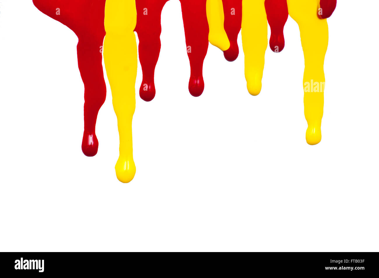 close up of red and yellow paint leaking on white background Stock Photo