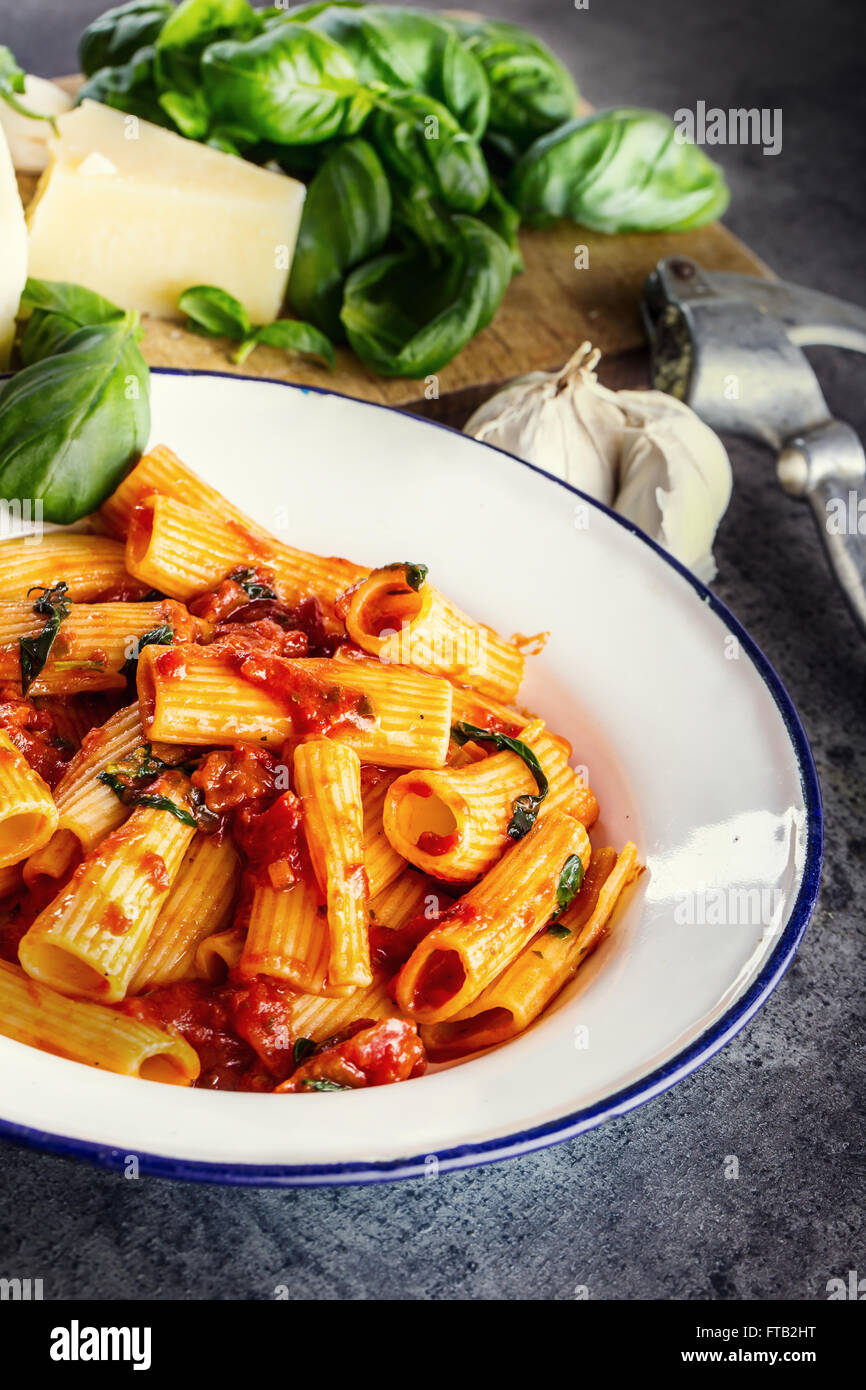 Pasta. Italian and Mediterranean cuisine. Pasta Rigatoni with tomato sauce basil leaves garlic and parmesan cheese. An old home Stock Photo