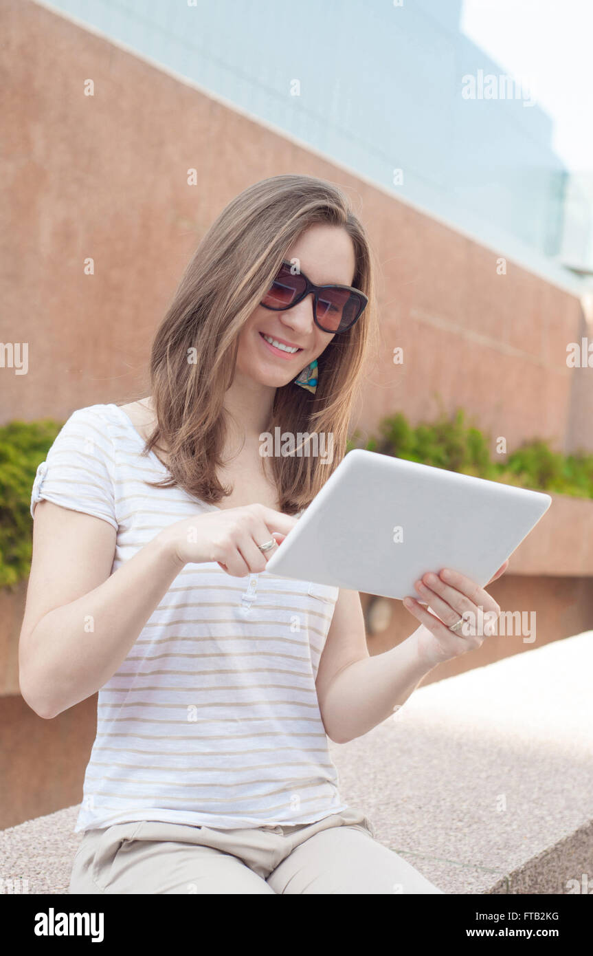 Young woman using digital tablet mobile outdoors in a city Stock Photo ...