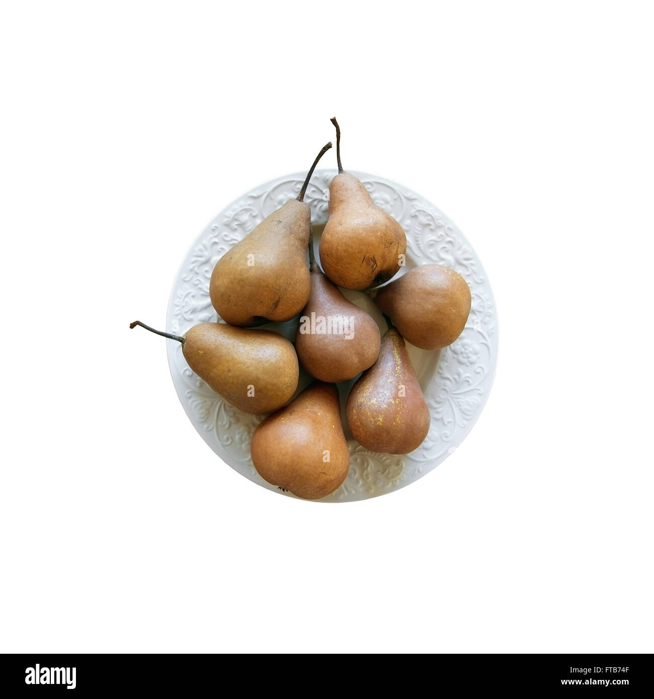 Seven pears on white plate on wood table isolated on white. Stock Photo