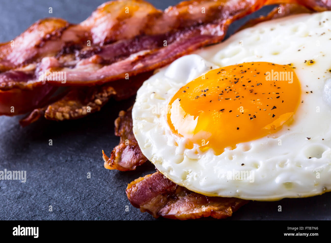 Ham and Egg. Bacon and Egg. Salted egg and sprinkled with black pepper. English breakfast. Stock Photo