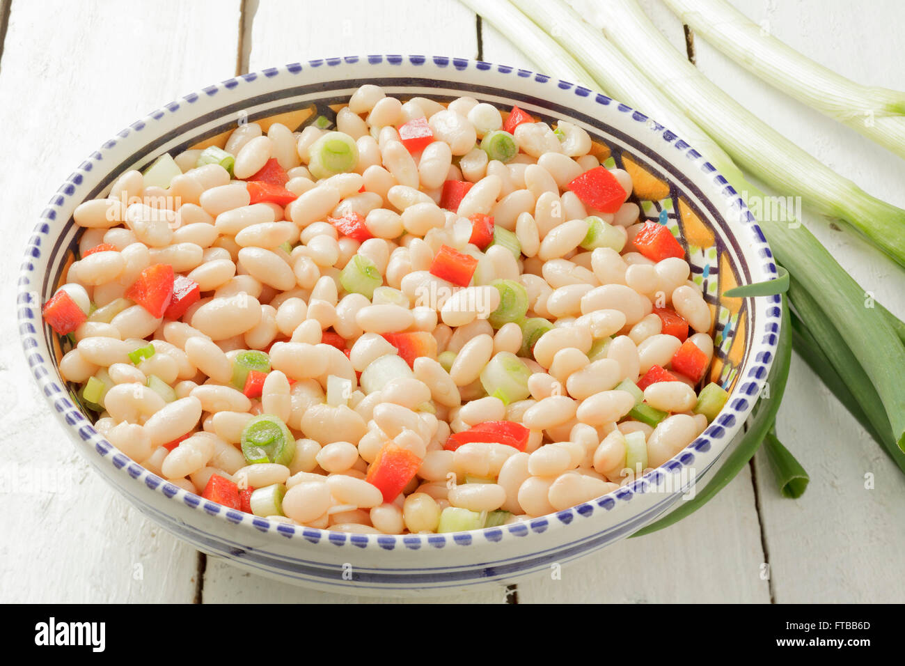 White bean salad with spring onions and red peppers Stock Photo