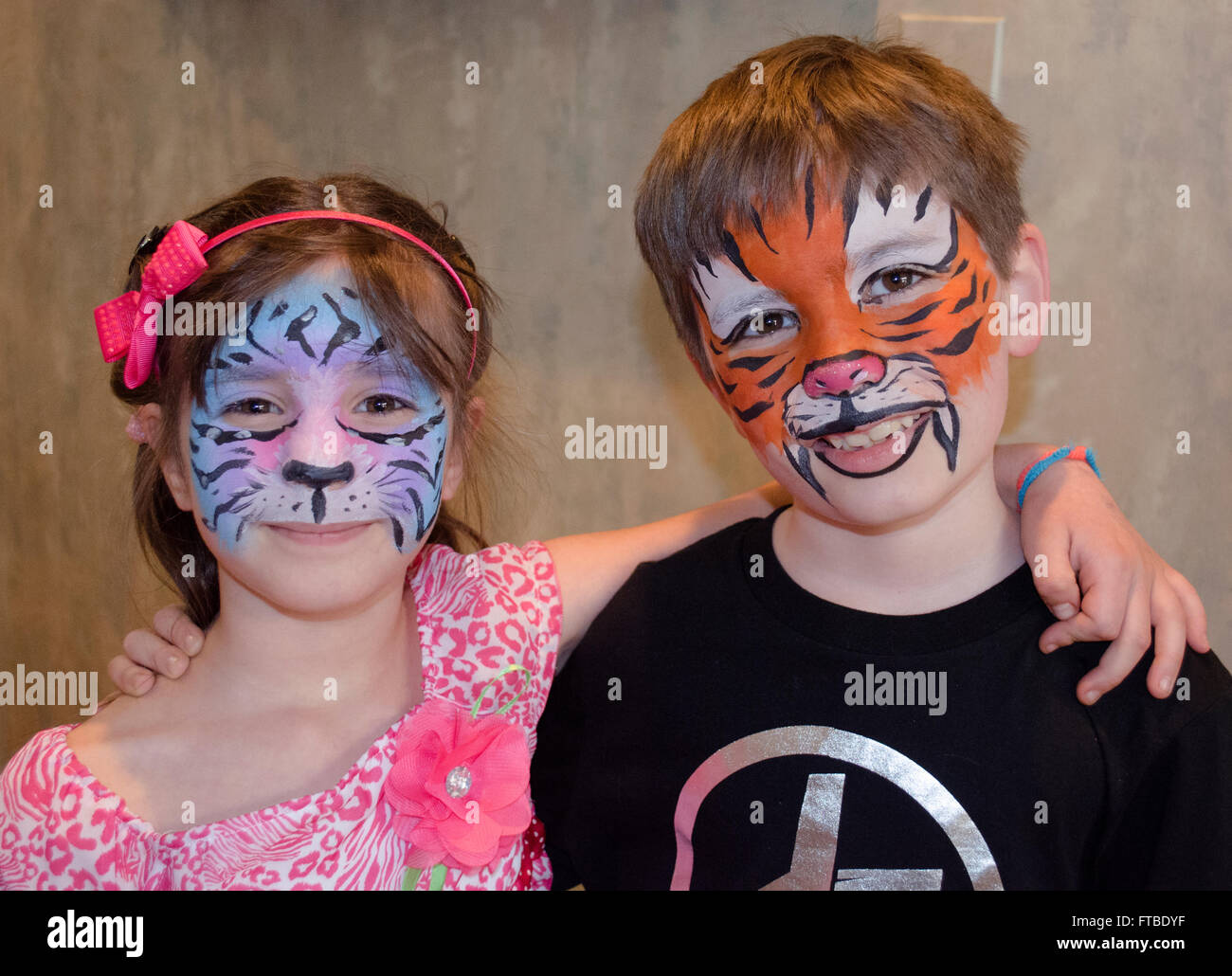 Boy and girl wearing animal face paint from party Stock Photo