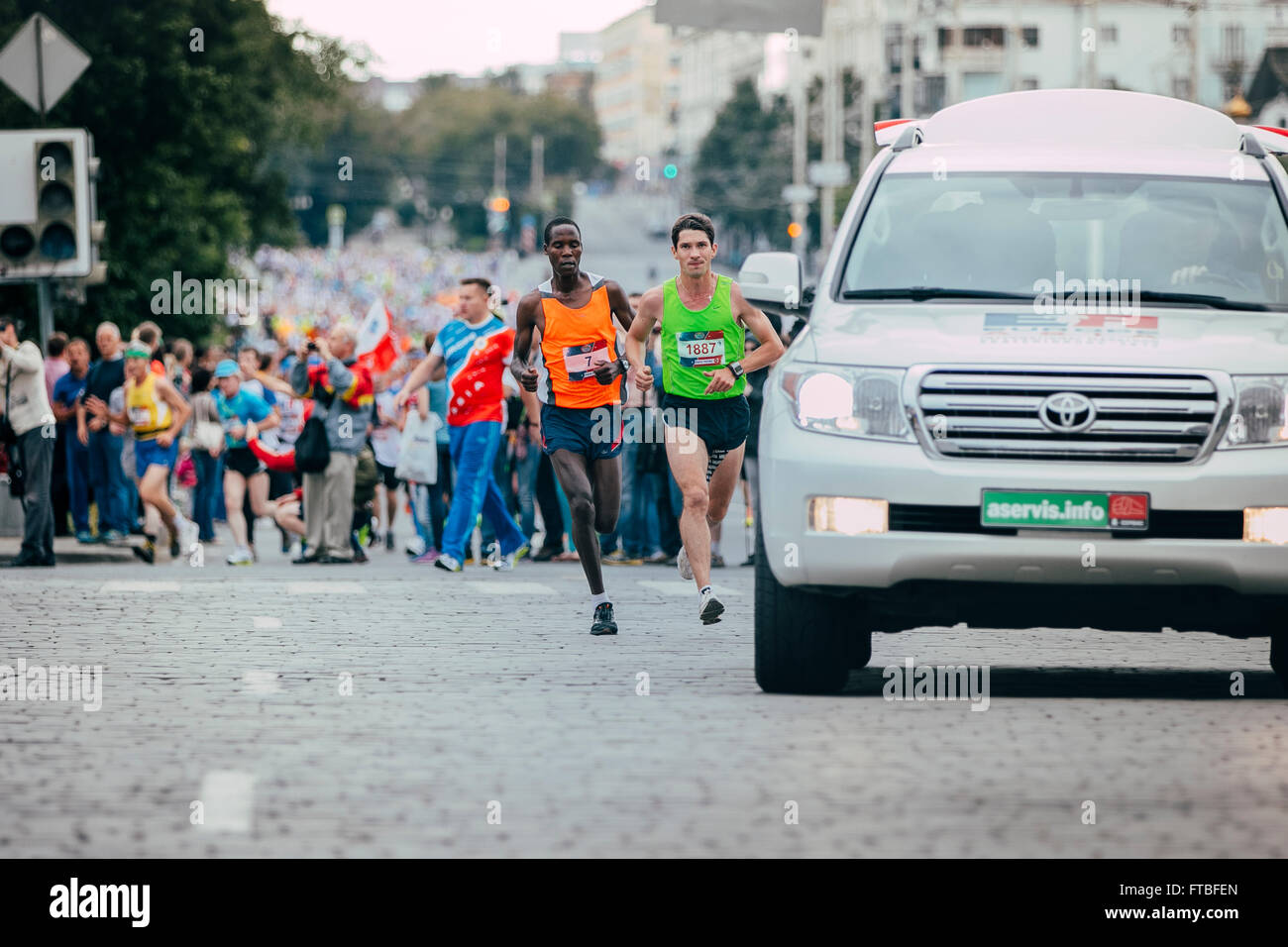 two athlete runner leaders of race run behind safety car during Marathon Europe-Asia Stock Photo