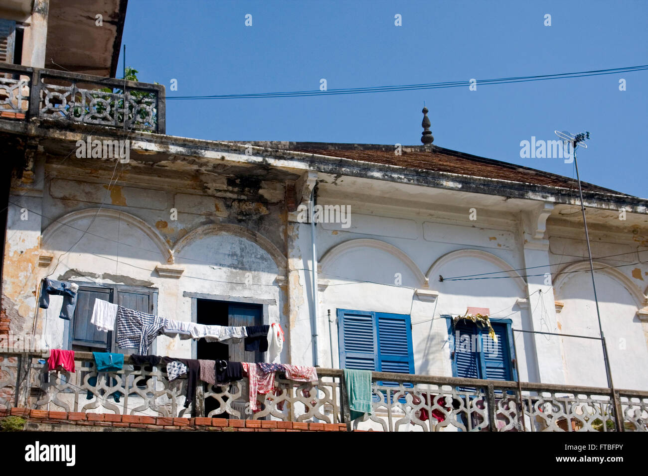 An old rundown colonial era building is part of the urban landscape in Kampong Cham, Cambodia. Stock Photo