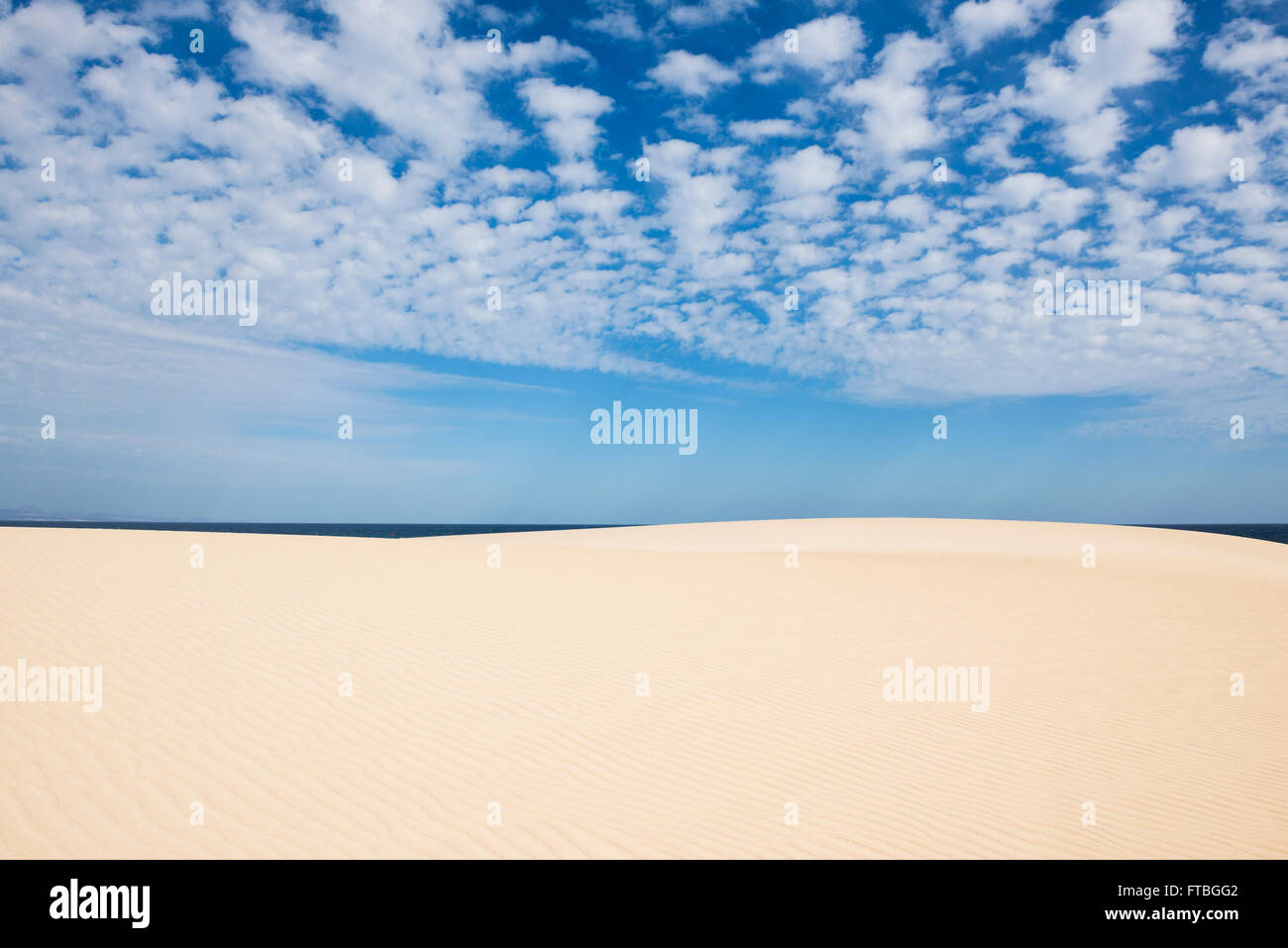 Dunes against blue sea, Corralejo Dunes Natural Park, Corralejo, Fuerteventura, Canary Islands, Spain Stock Photo