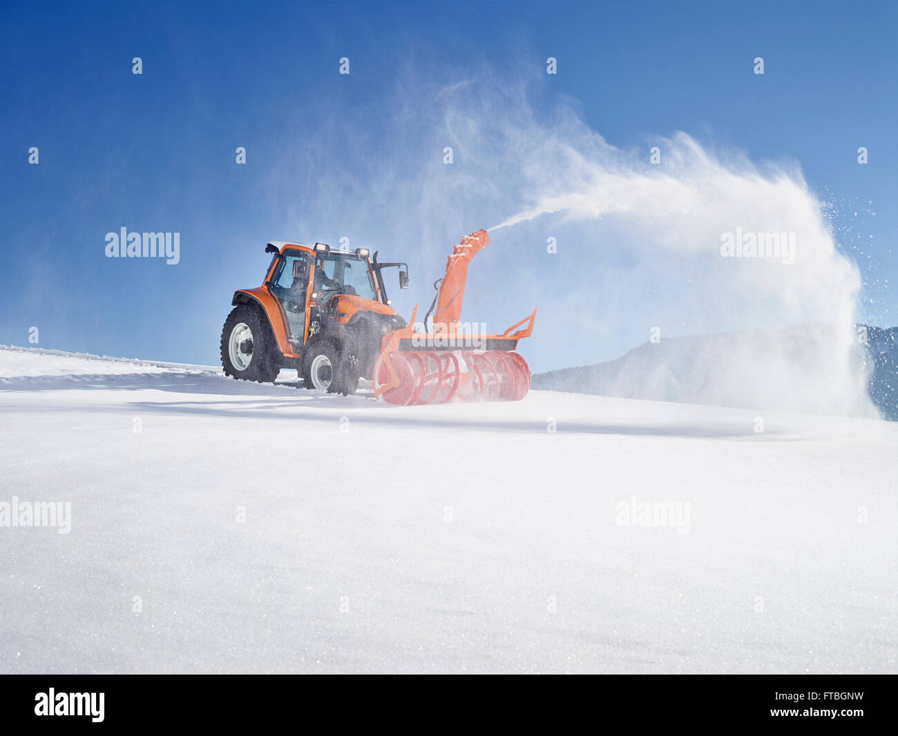 Tractor with a snow blower clearing snow, Winter services, Kundl, Inn