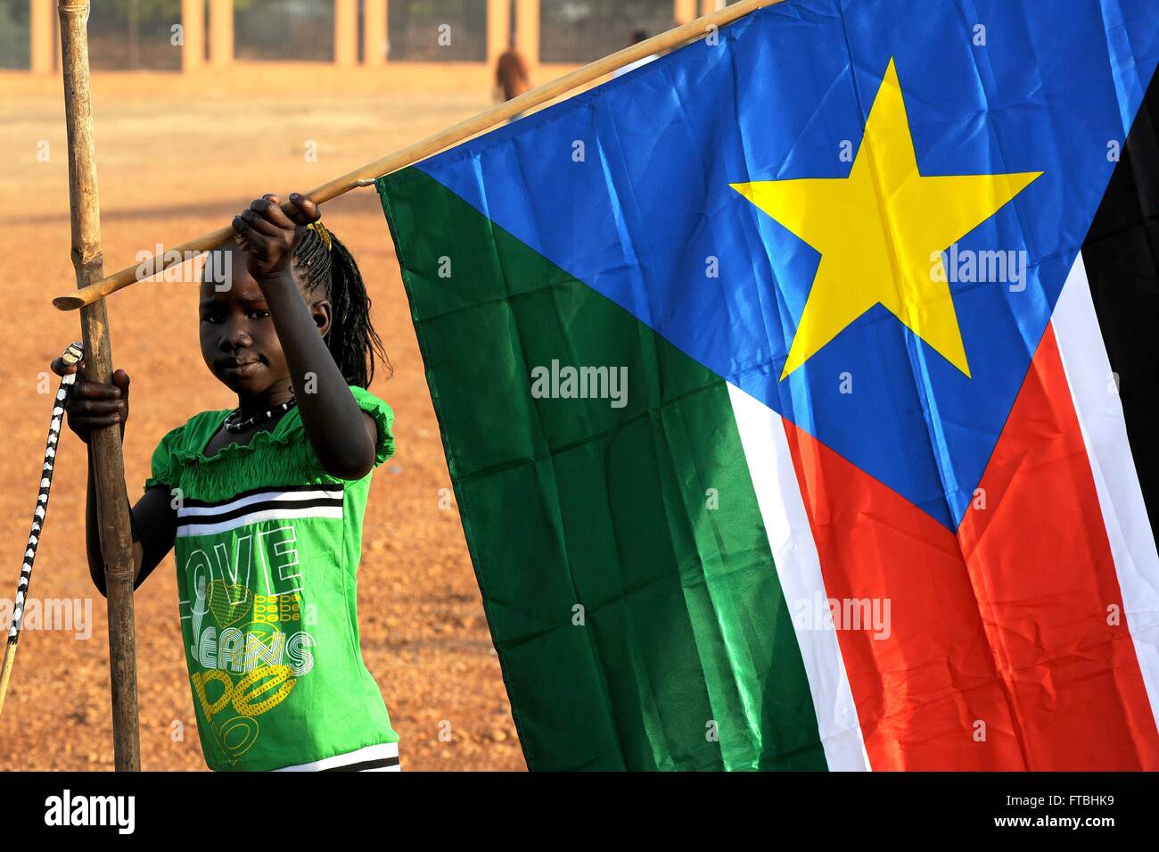 A young Sudanese girl hangs a flag of newly independent South Sudan during celebrations marking the birth of the new nation January 30, 2011 in Juba, South Sudan. Stock Photo