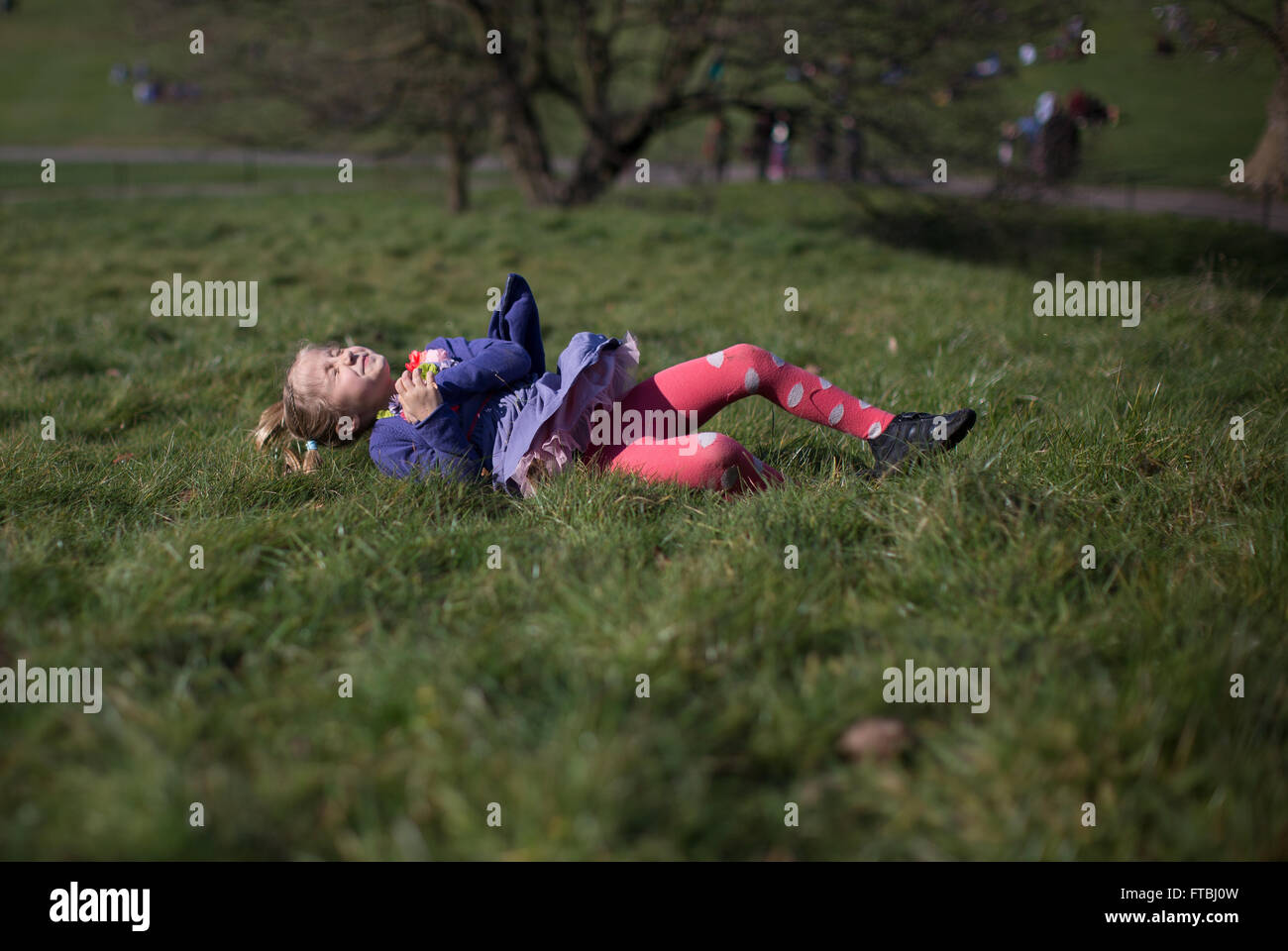 young girl body rolling down hill on the grass Stock Photo - Alamy