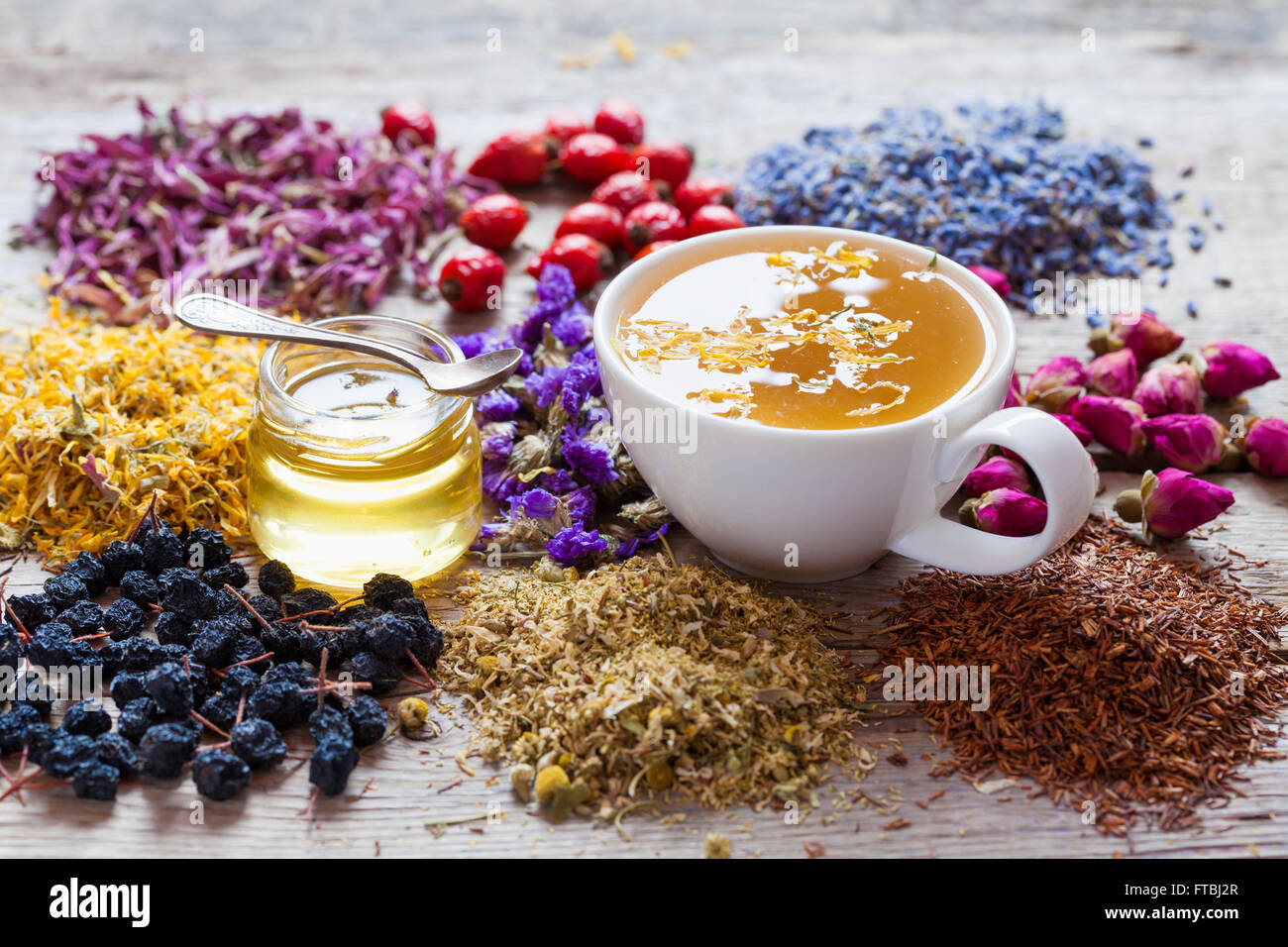 Cup of healthy tea, honey, healing herbs, herbal tea assortment and