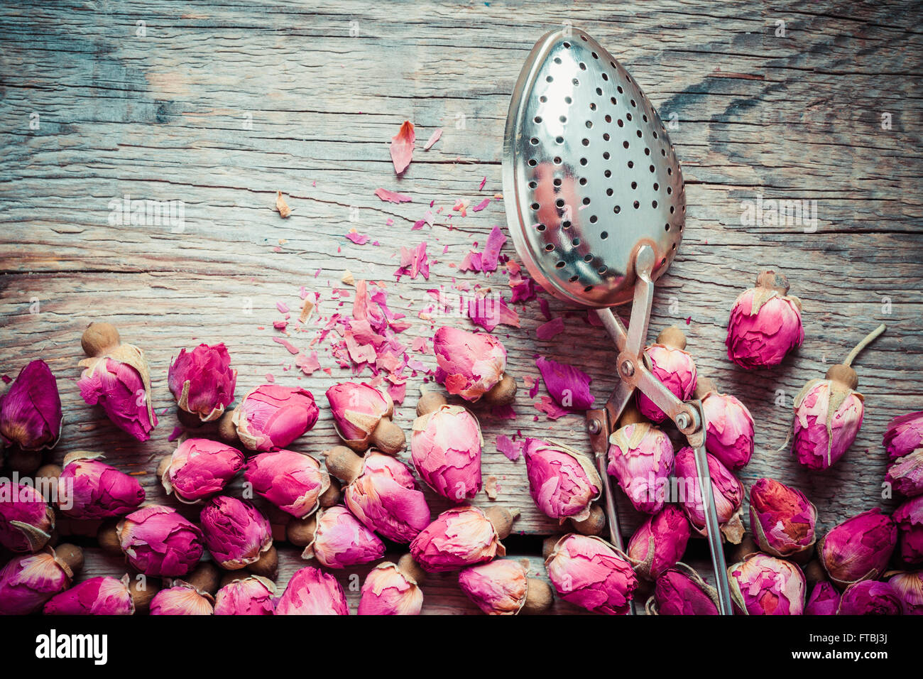 Dry rose buds tea and tea infuser. Top view. Stock Photo