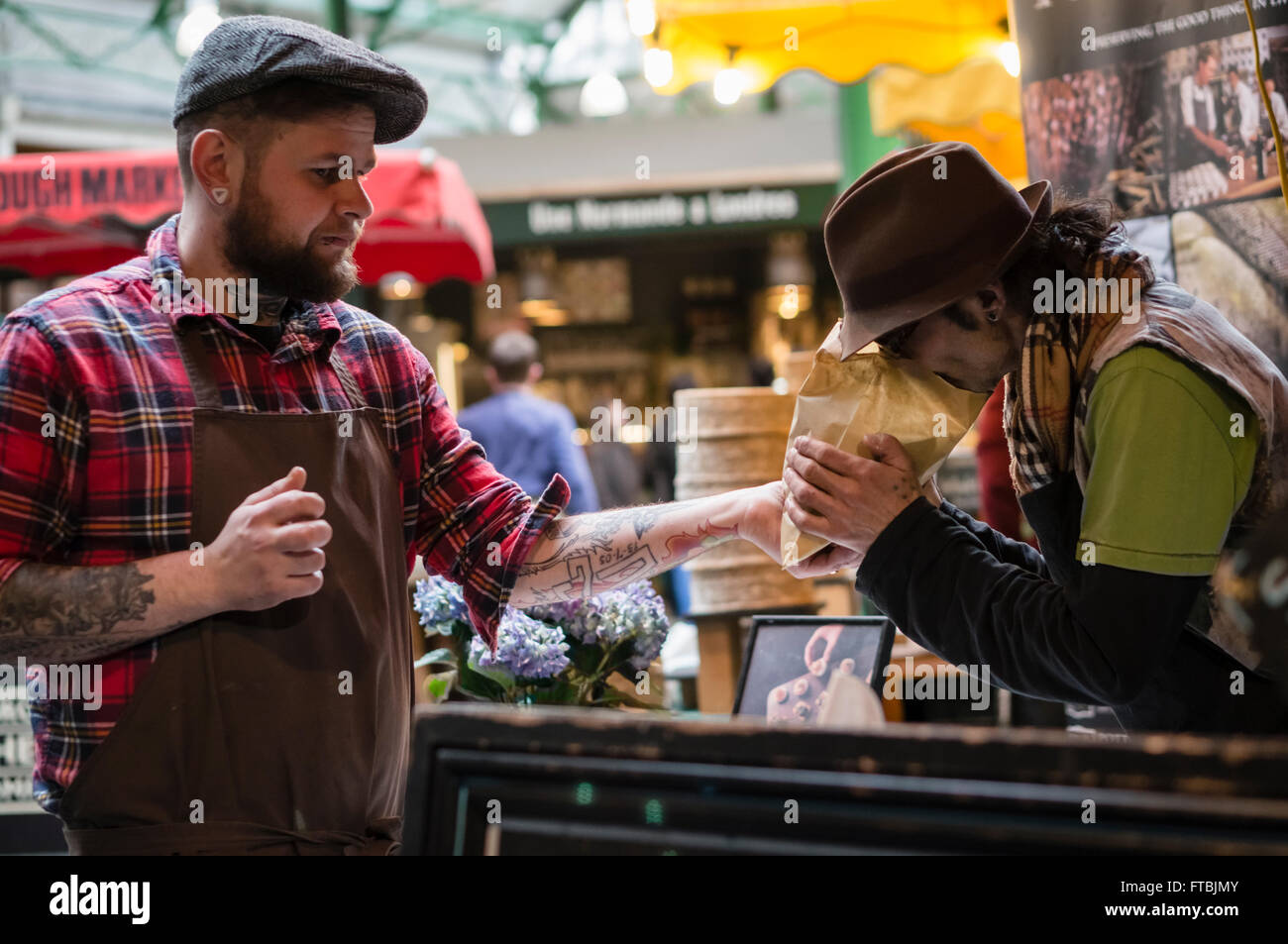 Two traders discuss produce at Borough Market, London, UK Stock Photo