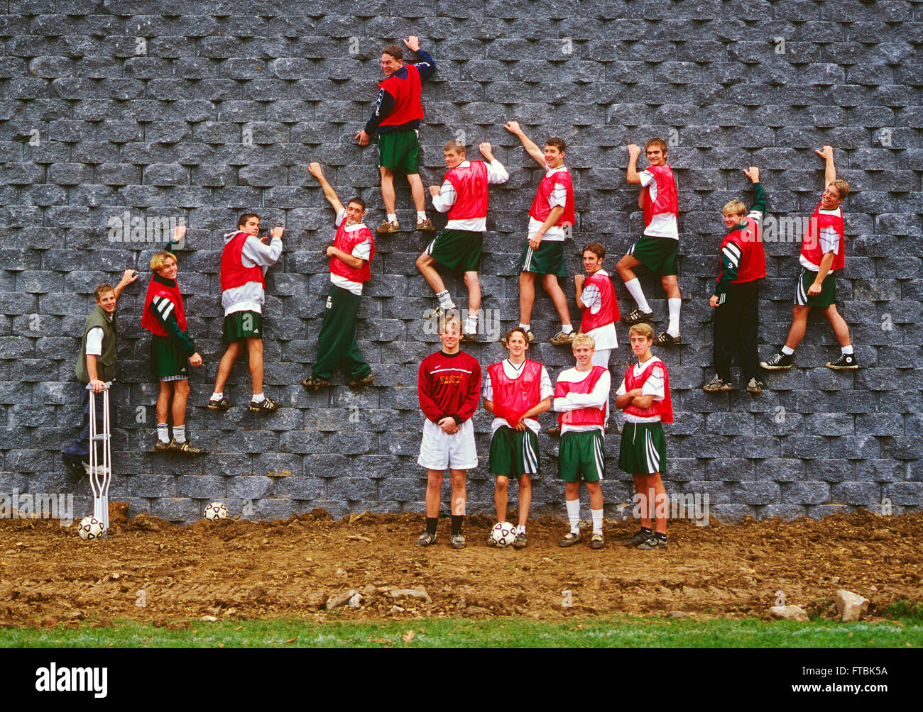 Team portrait of boy's high school student soccer team posed on wall Stock Photo