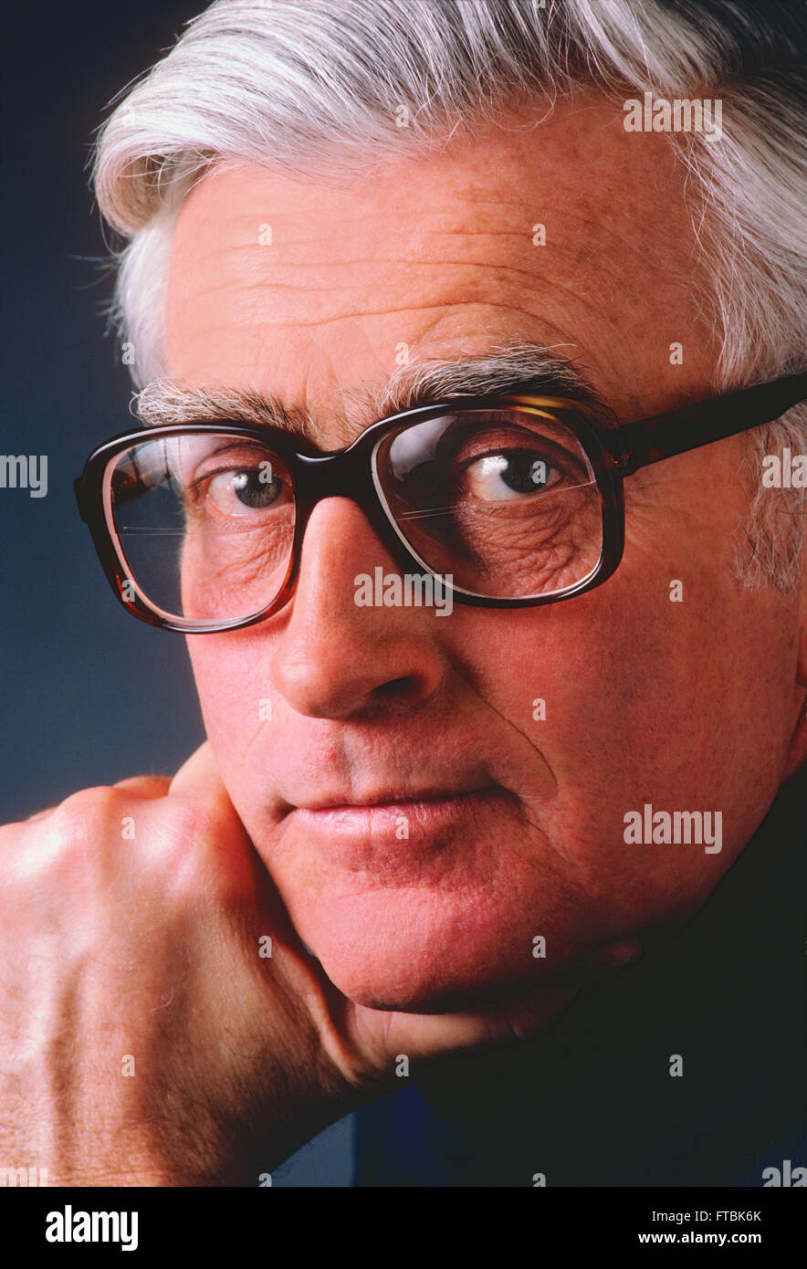 Studio portrait of distinquished gentleman with eyeglasses & silver grey hair Stock Photo