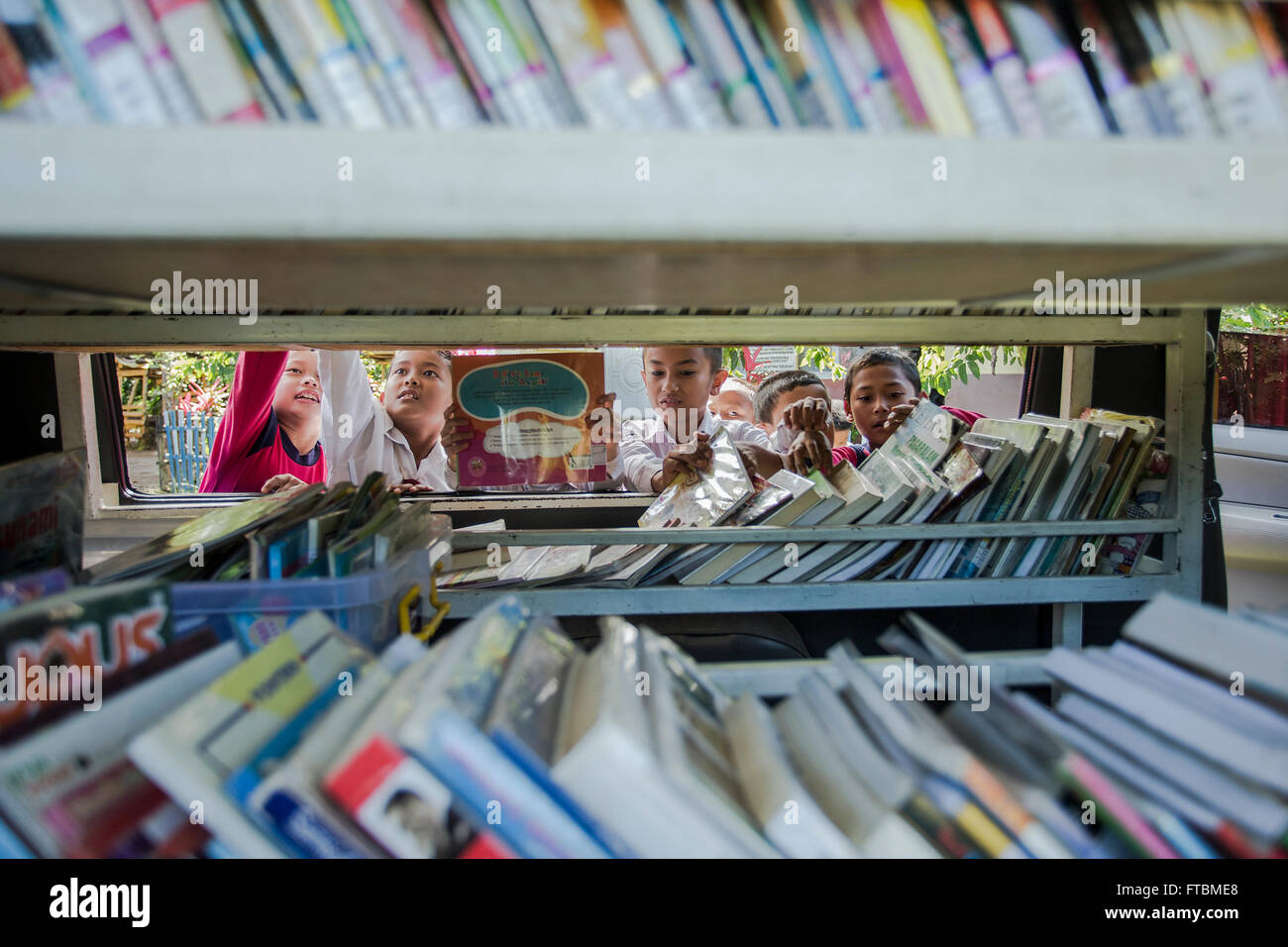Students of primary school is very enthusiastic about choosing the books in the library car Stock Photo
