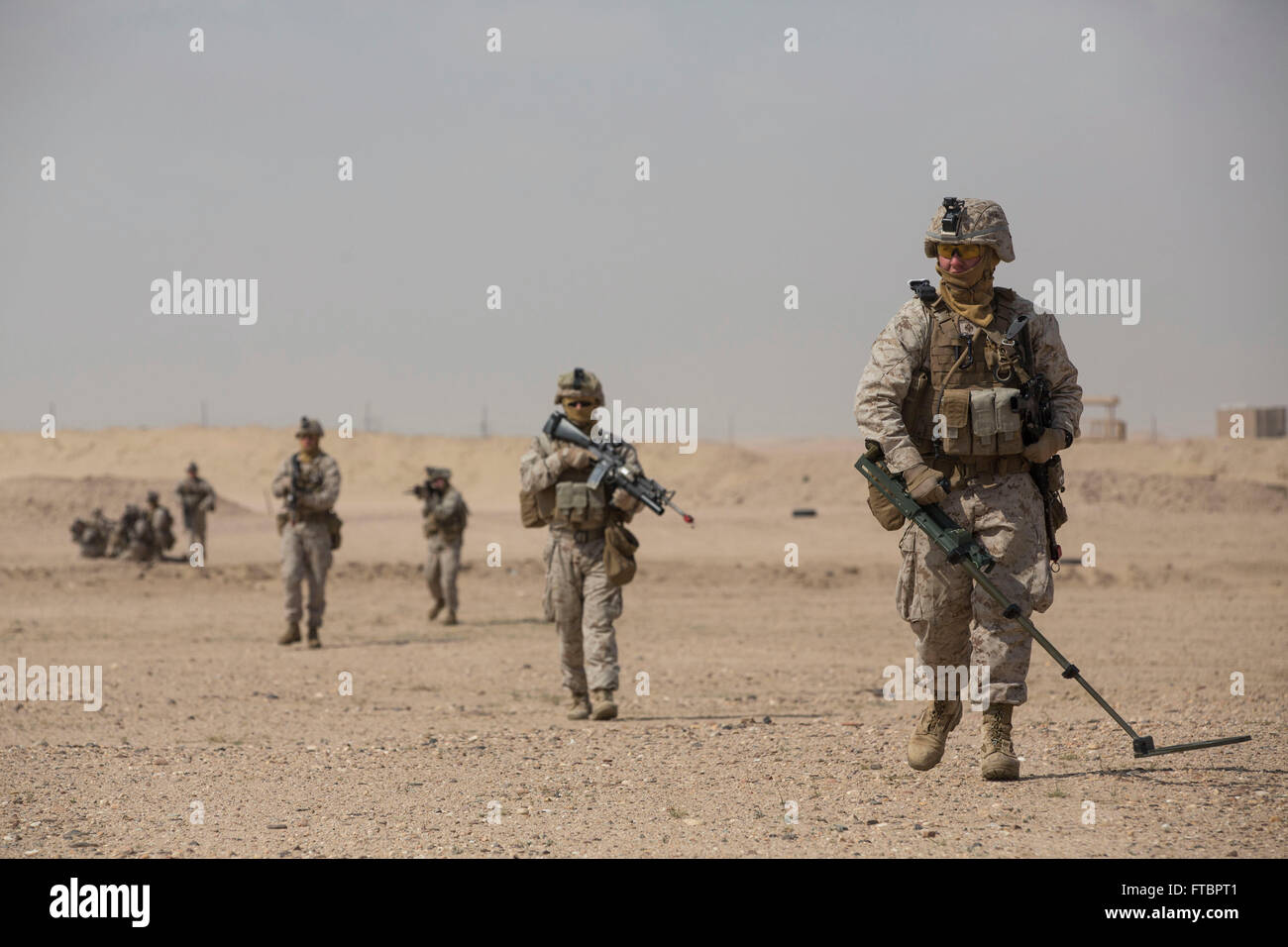 A U.S. Marine combat engineer checks for improvised explosive devices while leading a patrol during a training exercise February 22, 2015 at Udairi Range, Kuwait. Stock Photo