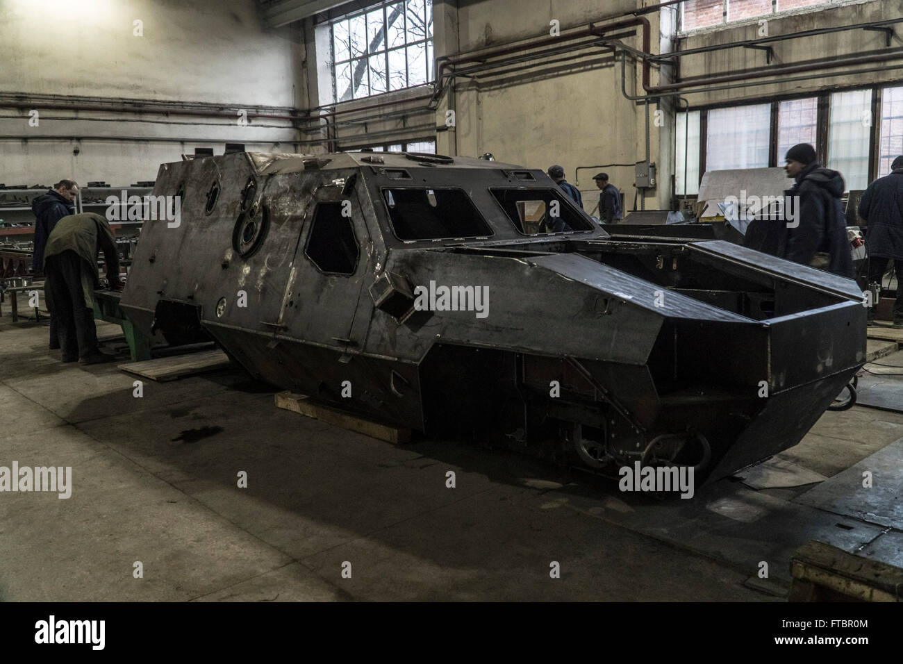 Workers carry out work on the shell of a DozorB armoured personnel