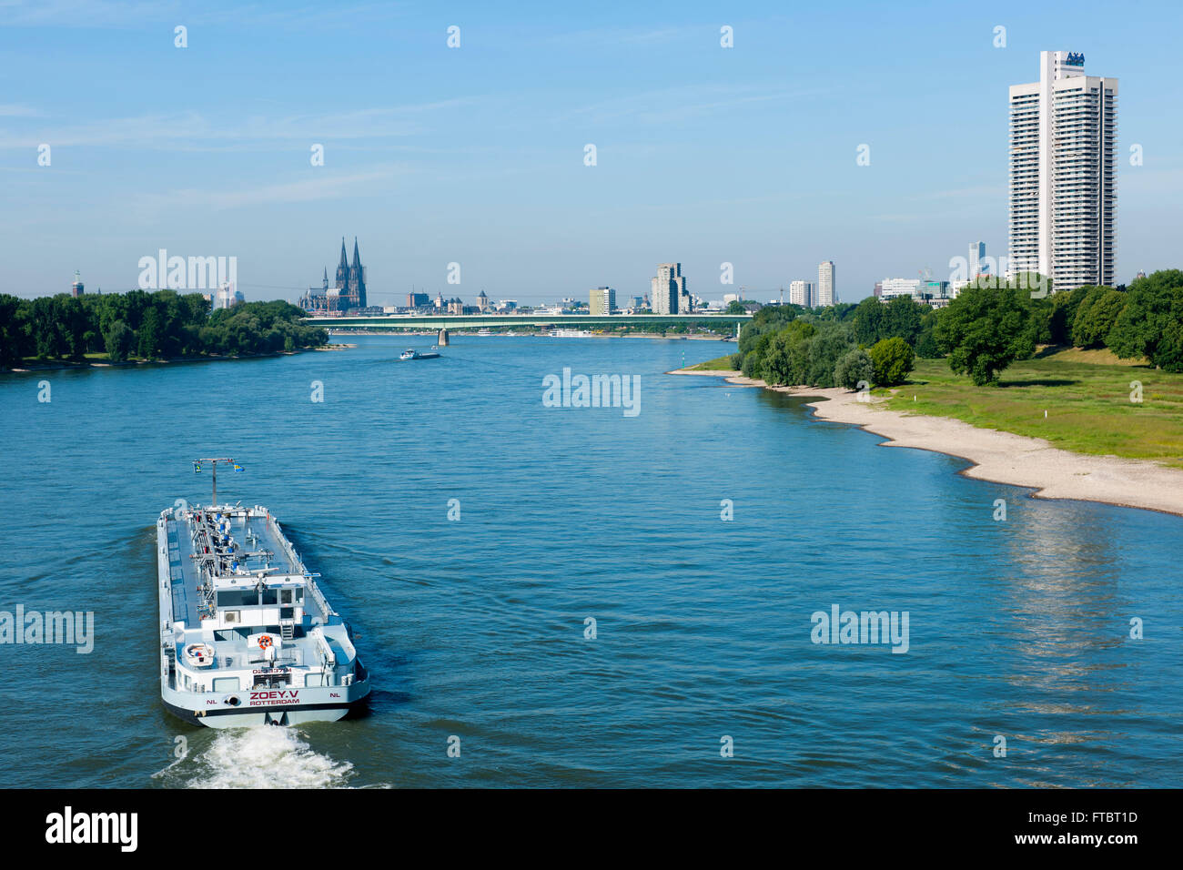 Deutschland, Köln, Blick von der Mühlheimer Brücke über euin Frachtschiff auf das linke Rheinufer und zum Colonia Haus. Stock Photo