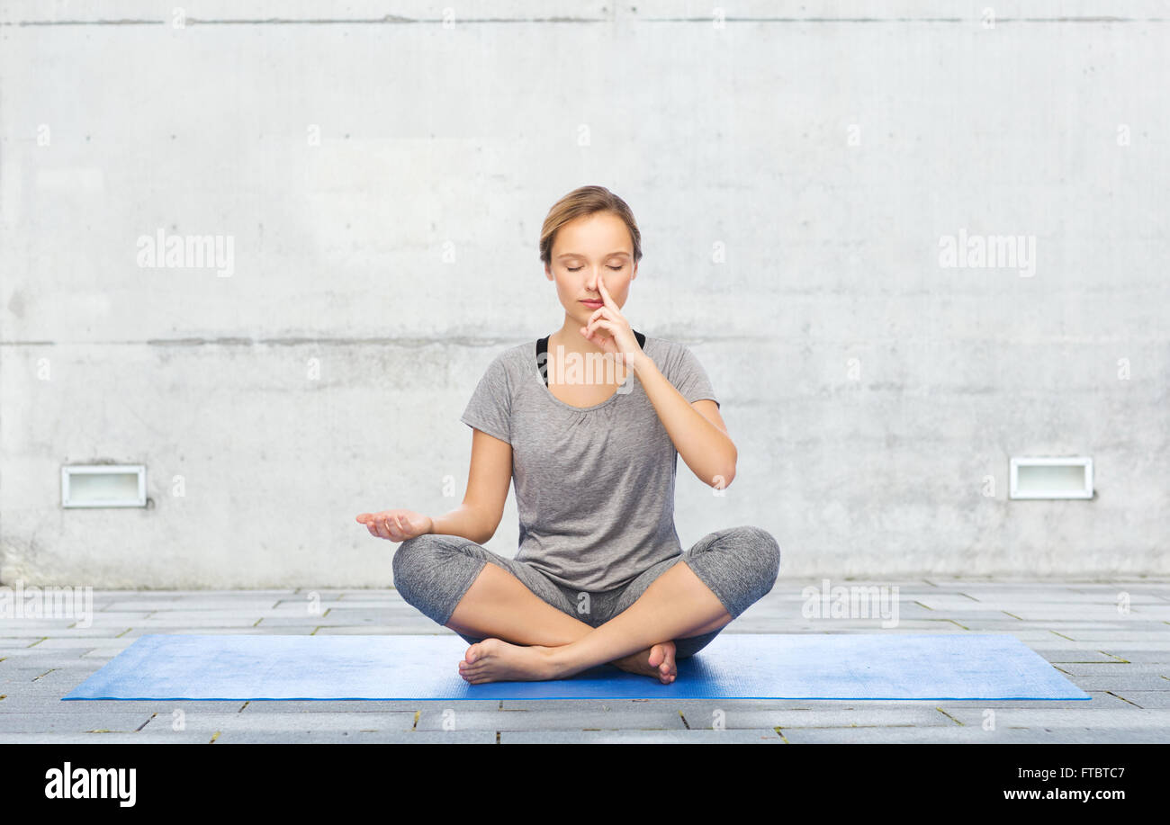 woman making yoga meditation in lotus pose on mat Stock Photo - Alamy