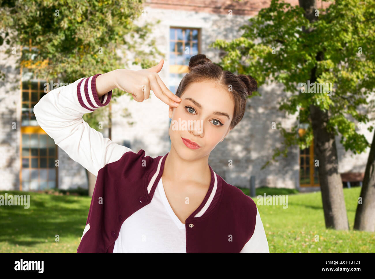 bored teenage girl making finger gun gesture Stock Photo