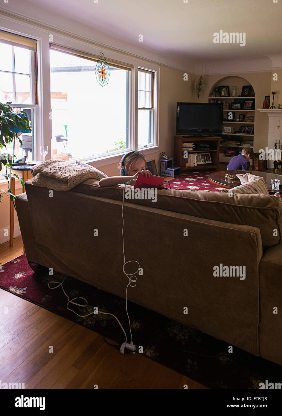 Two kids hanging out playing computer games, together alone. Stock Photo